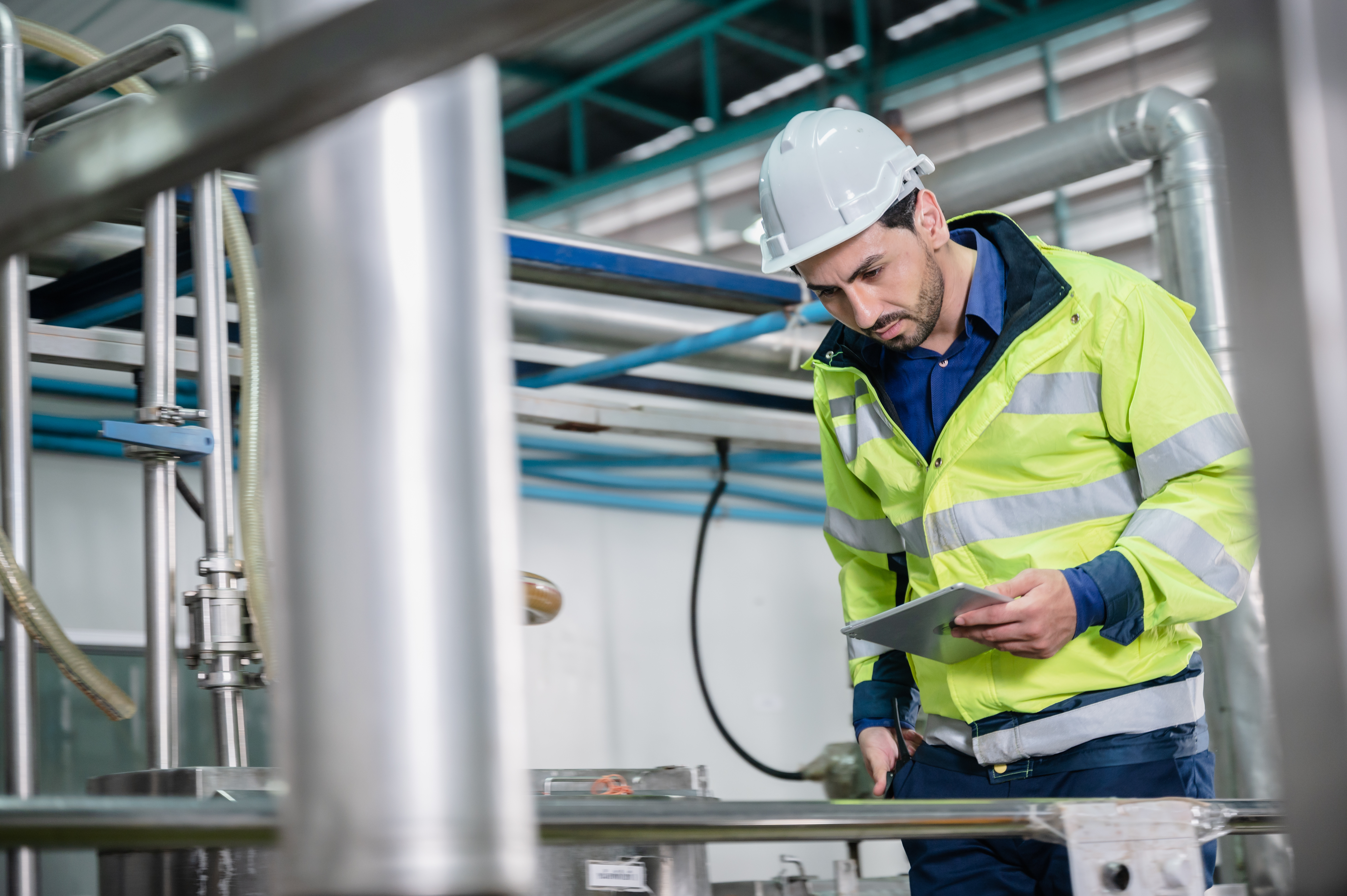 Technician verifying plant equipment with a mobile device